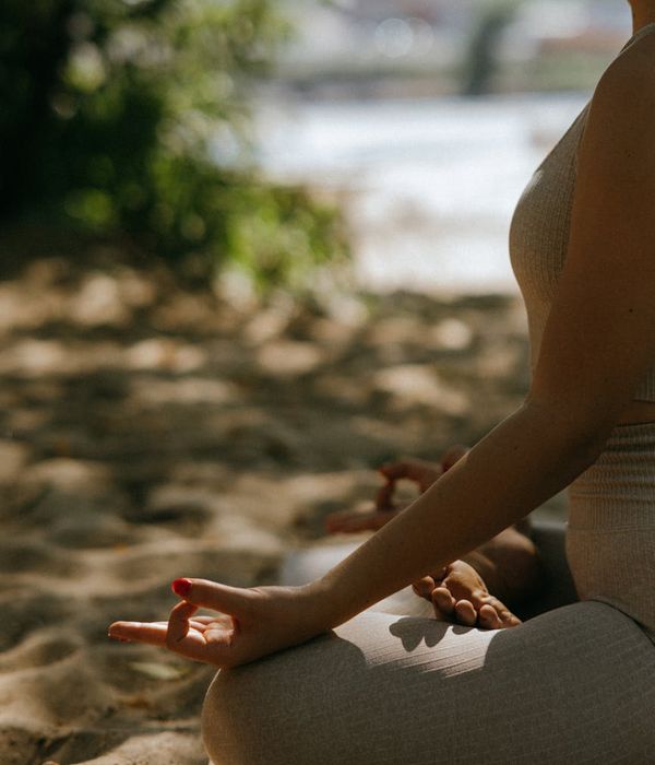 Person practicing mindfulness meditation in serene natural environment